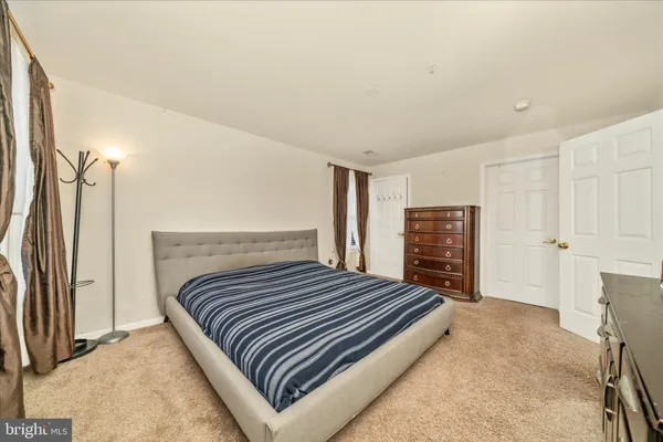 a bedroom with a bed and a refrigerator