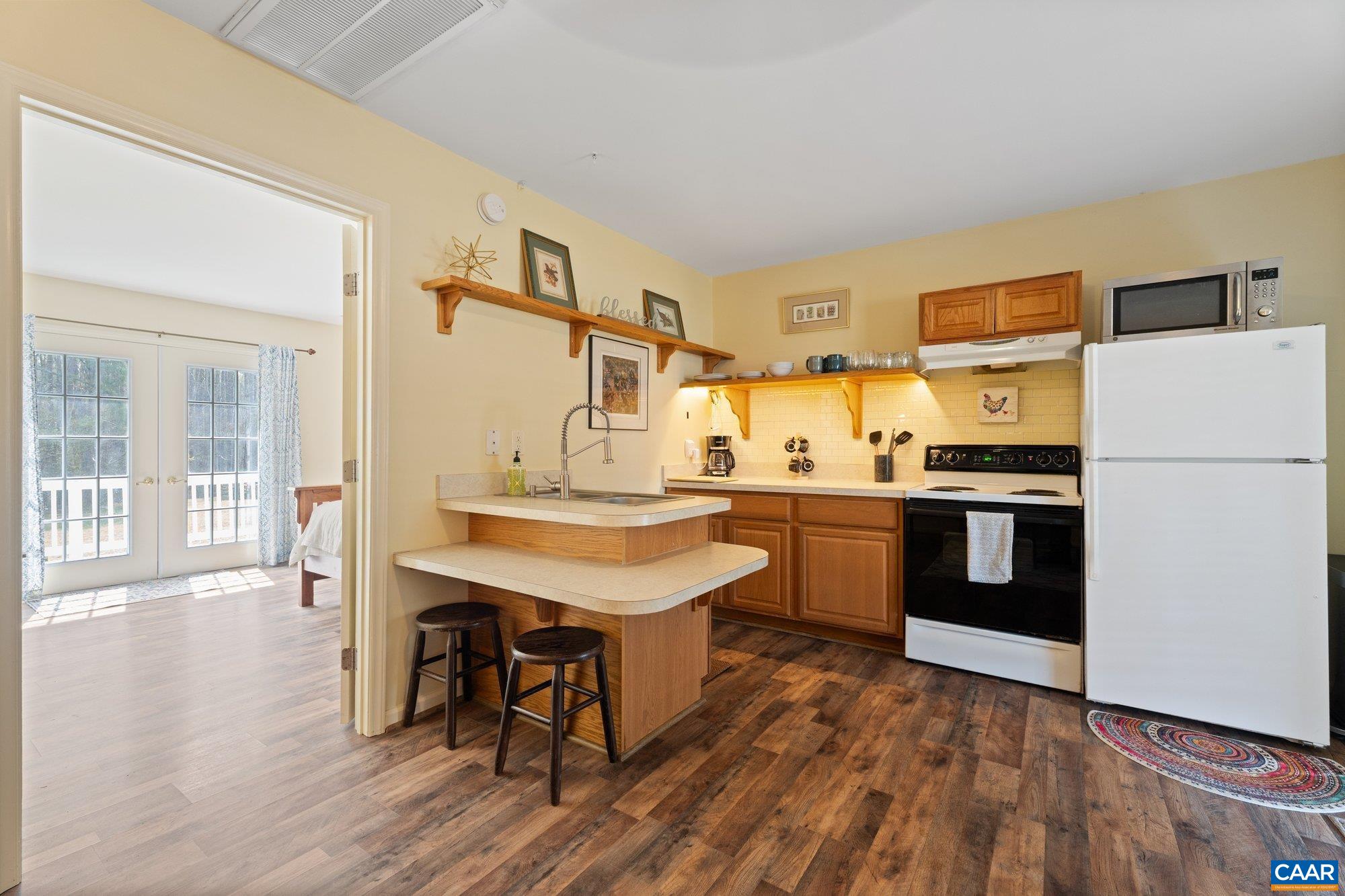 14910 Western Mill Road Lawrenceville, VA 23868 - Photo 66 of 73 a kitchen with stainless steel appliances a stove a sink dishwasher a refrigerator white cabinets and wooden floor