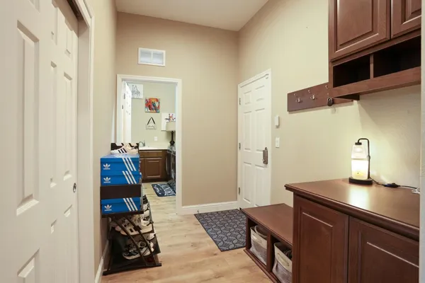 a hallway with a view of bedroom with wooden floor