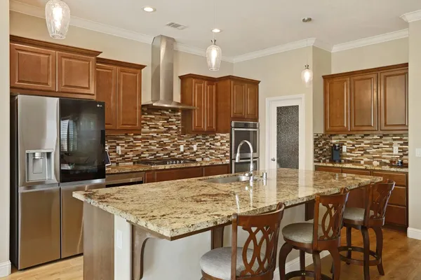 a kitchen with stainless steel appliances kitchen island granite countertop a table and chairs