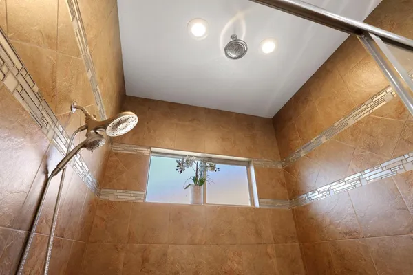 a spacious bathroom with a granite countertop sink a mirror and shower