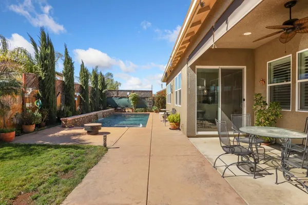 a view of a patio with couches and table and chairs and potted plants