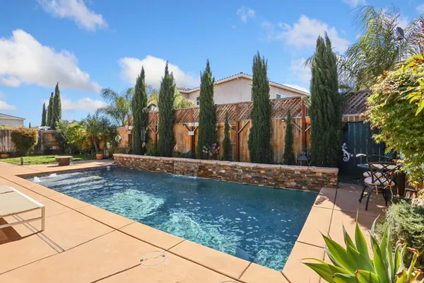 a view of a house with backyard and sitting area