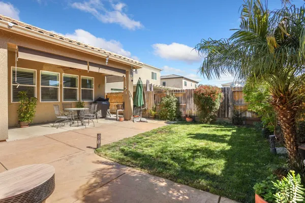 a view of a patio with couches table and chairs and potted plants
