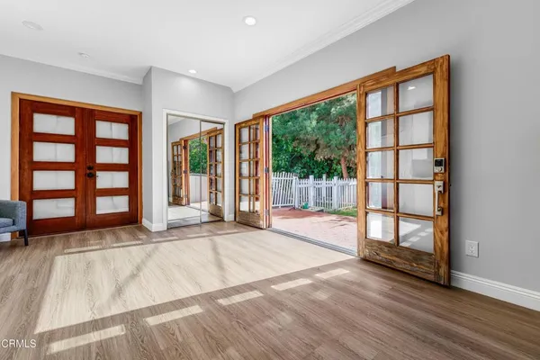 a view of an empty room with wooden floor and a window
