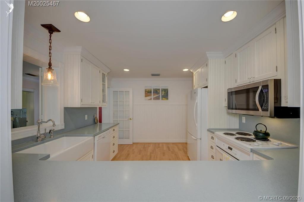 904 Southeast Riverside Drive Stuart, FL 34994 - Photo 37 of 72 a large white kitchen with stainless steel appliances granite countertop a sink a stove and a refrigerator