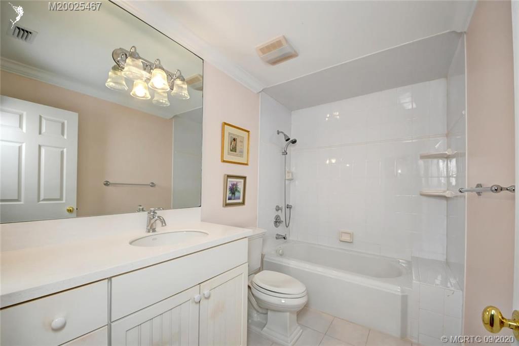 904 Southeast Riverside Drive Stuart, FL 34994 - Photo 48 of 72 a bathroom with a bathtub shower sink mirror vanity and toilet