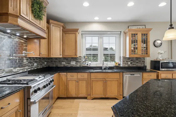 a kitchen with stainless steel appliances granite countertop a stove and a sink