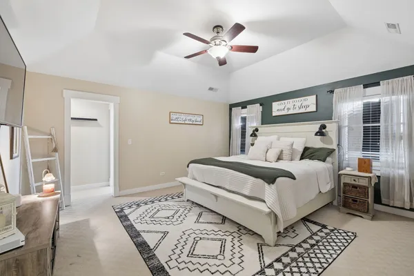 a bedroom with a large bed and a chandelier