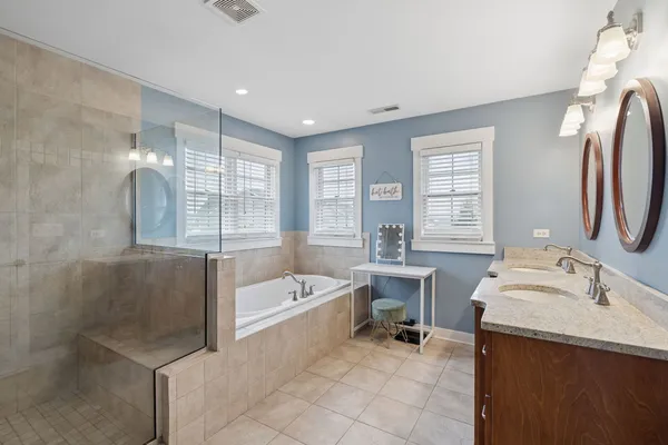a spacious bathroom with a bathtub sink and mirror