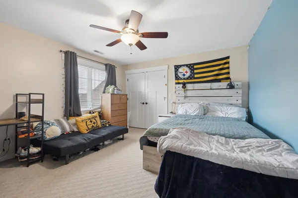 a bedroom with a bed and dresser with mirror