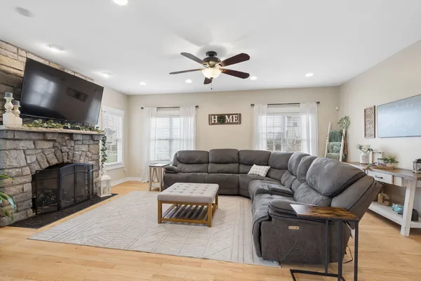 a living room with furniture a flat screen tv and a fireplace