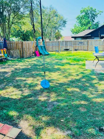 a view of a backyard with table and chairs and wooden fence