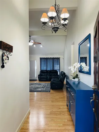 a view of a living room and kitchen with a chandelier
