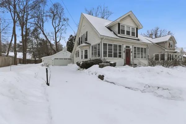 a front view of a house with a yard covered in snow