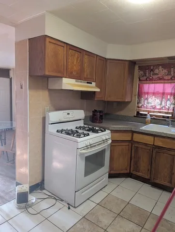 a kitchen with granite countertop a stove a sink and a microwave