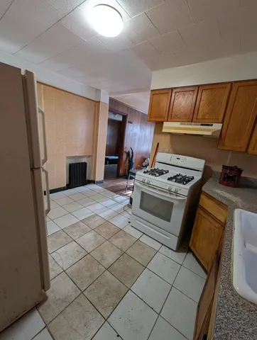 a kitchen with granite countertop a sink stove and refrigerator