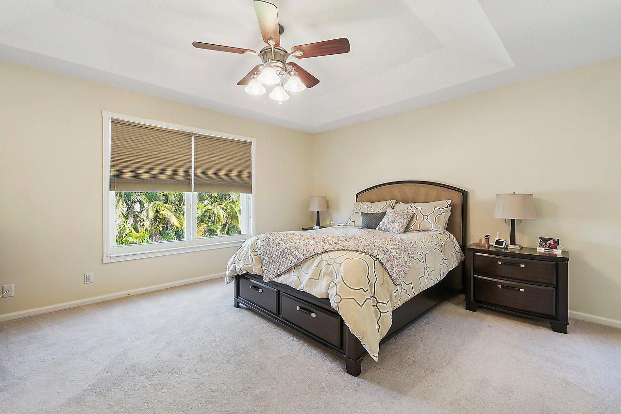 5731 Raceway Road Lake Worth, FL 33449 - Photo 14 of 43 a spacious bedroom with a bed and a chandelier