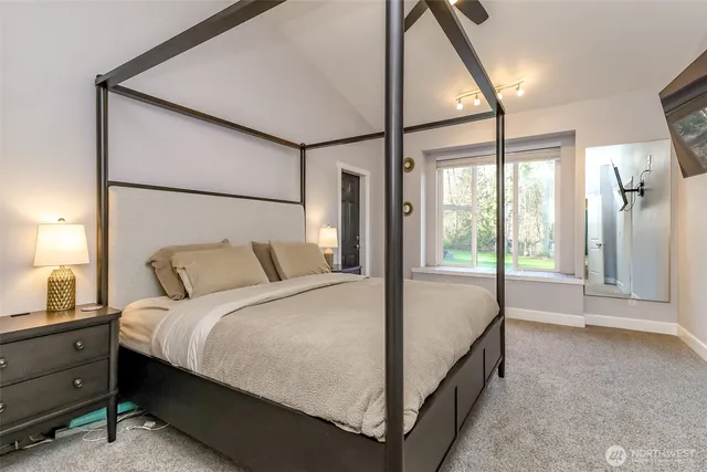 a bed sitting in a bedroom next to a window