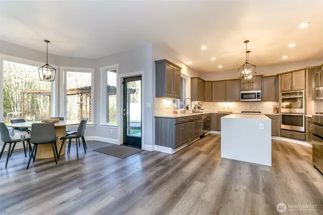 a kitchen with kitchen island granite countertop stainless steel appliances cabinets a sink and a counter top