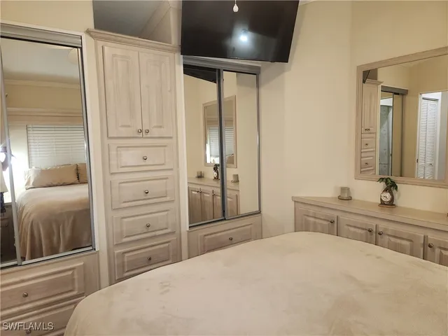a bedroom with a bed and a large mirror