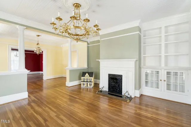 a view of a room with wooden floor fireplace and windows