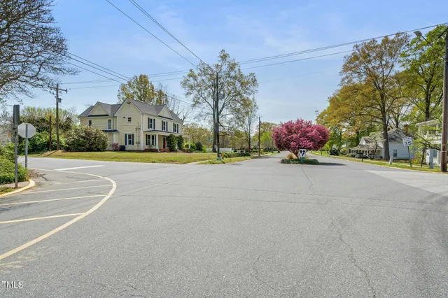 a front view of a house with a yard and trees