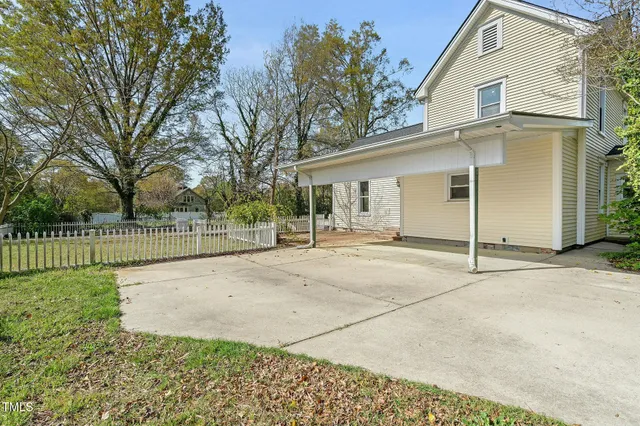 a view of a white house with a outdoor space and trees