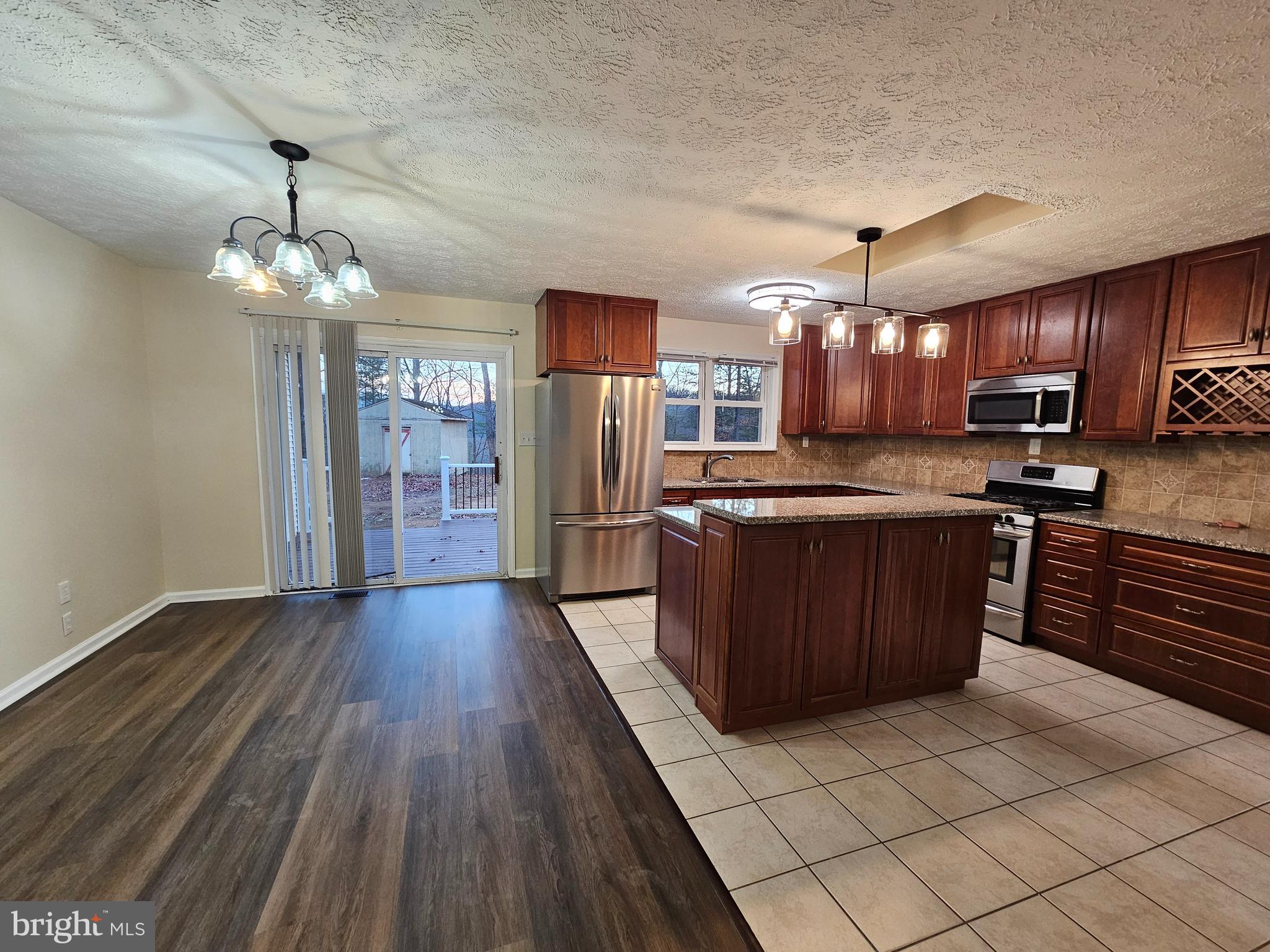 310 Blue Mountain Road Front Royal, VA 22630 - Photo 12 of 24 a large kitchen with stainless steel appliances granite countertop a stove and a wooden cabinets
