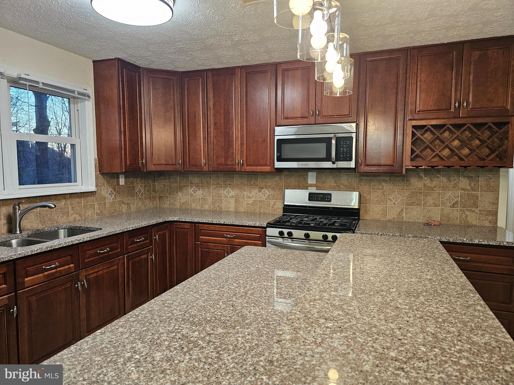310 Blue Mountain Road Front Royal, VA 22630 - Photo 13 of 24 a kitchen with granite countertop wooden cabinets and a stove top oven