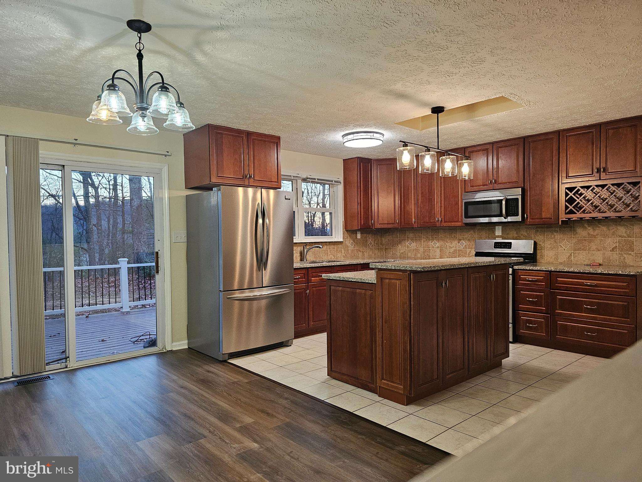 310 Blue Mountain Road Front Royal, VA 22630 - Photo 14 of 24 a kitchen with stainless steel appliances granite countertop a refrigerator oven a sink dishwasher and wooden cabinets with wooden floor