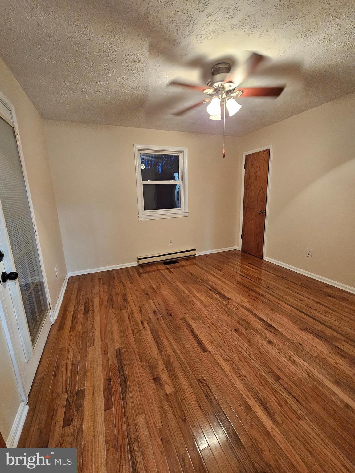 310 Blue Mountain Road Front Royal, VA 22630 - Photo 20 of 24 a view of an empty room with wooden floor and a ceiling fan