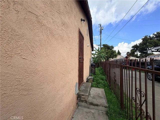 a view of a pathway of a house with wooden fence