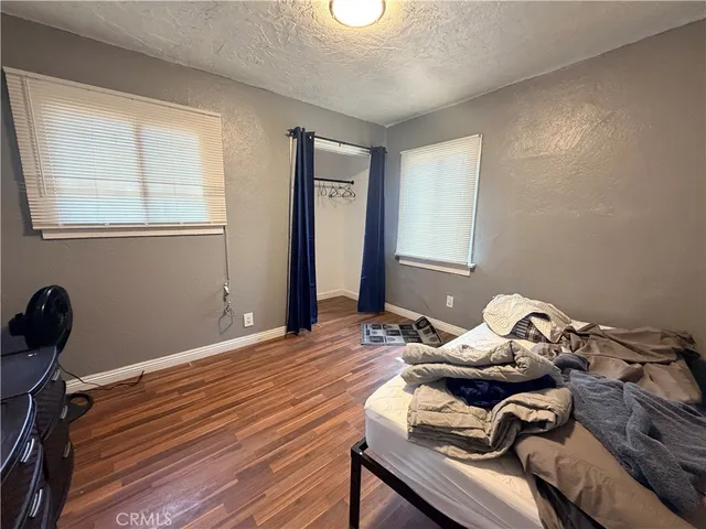 a bedroom with a bed and wooden floor