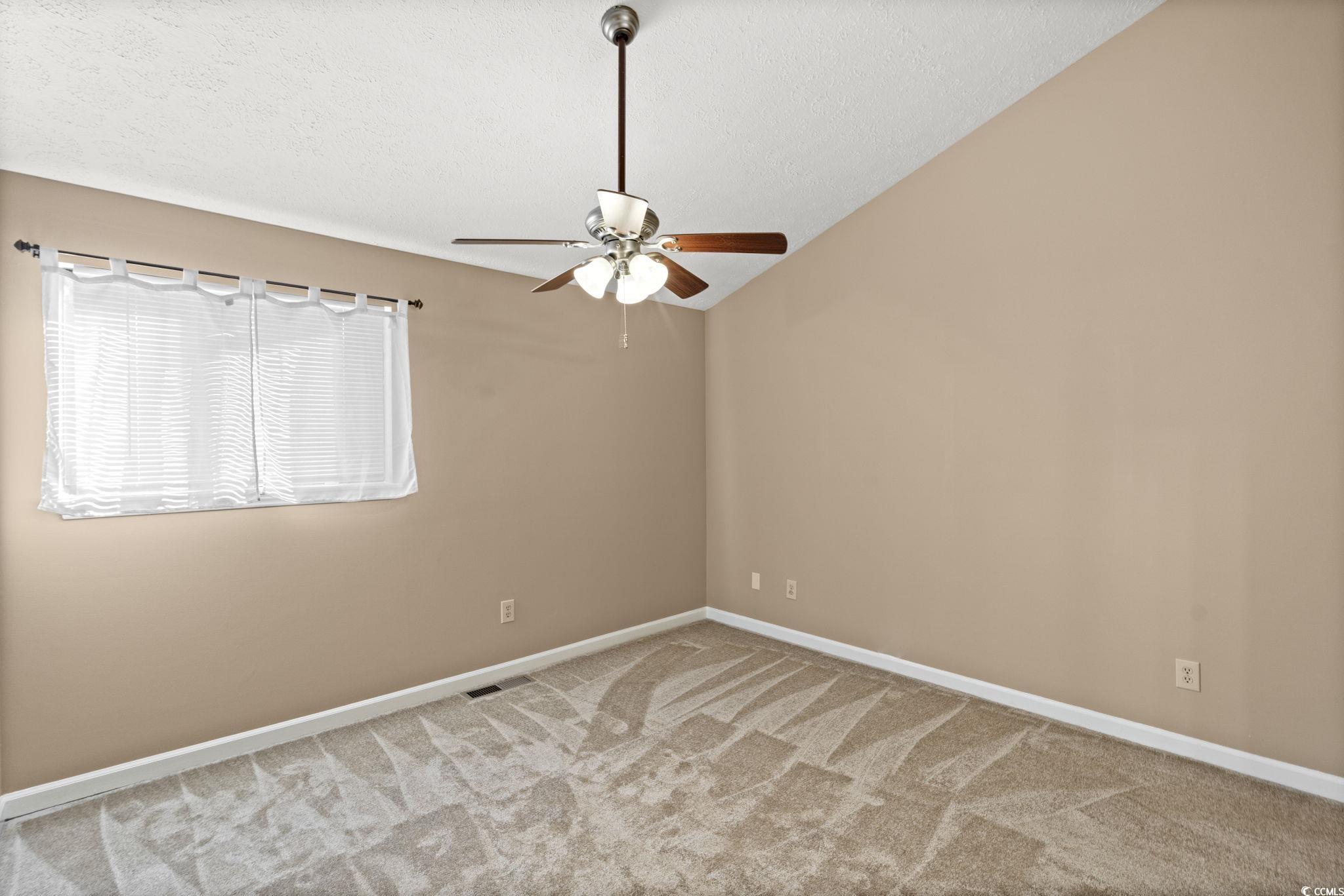 613 14th Avenue South, Unit 34 Surfside Beach, SC 29575 - Photo 13 of 37 Empty room with a textured ceiling, carpet floors, vaulted ceiling, and ceiling fan
