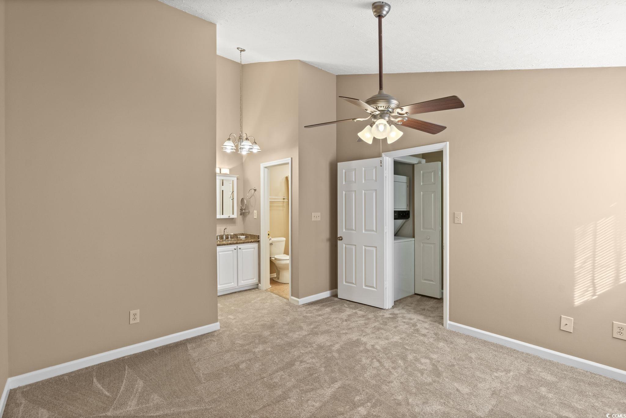 613 14th Avenue South, Unit 34 Surfside Beach, SC 29575 - Photo 14 of 37 Unfurnished bedroom featuring high vaulted ceiling, a chandelier, light colored carpet, connected bathroom, and washer / dryer