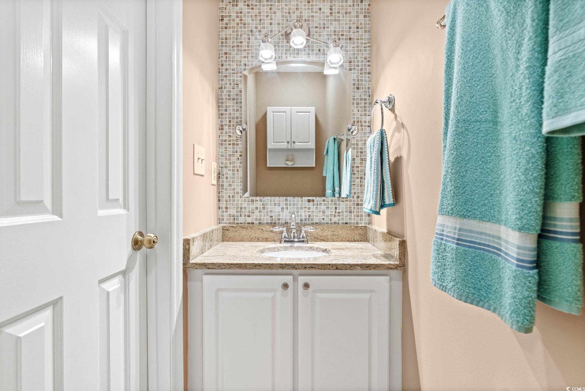 613 14th Avenue South, Unit 34 Surfside Beach, SC 29575 - Photo 19 of 37 Half bathroom featuring vanity and backsplash