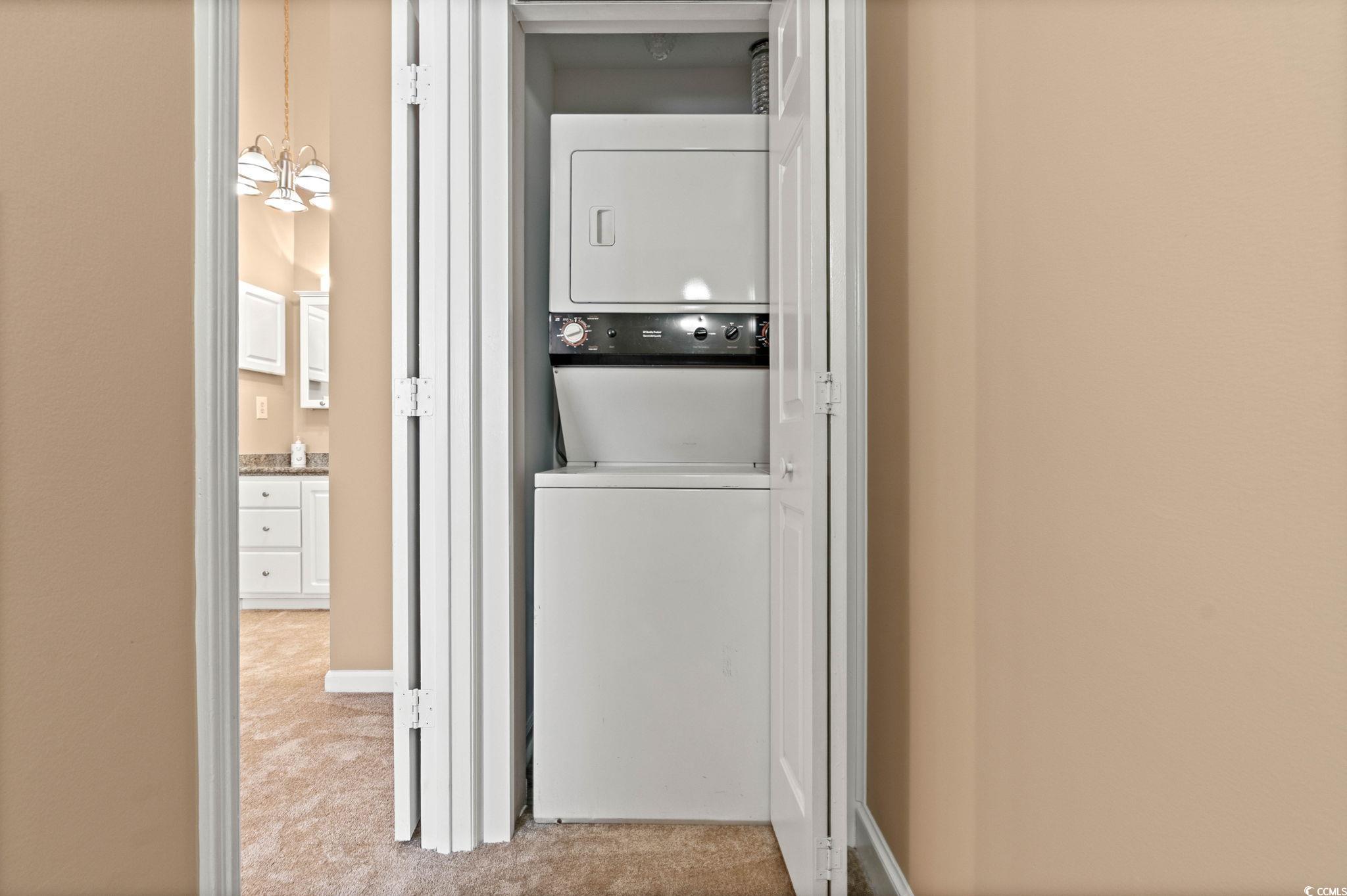 613 14th Avenue South, Unit 34 Surfside Beach, SC 29575 - Photo 20 of 37 Washroom with light colored carpet, stacked washer / drying machine, and a chandelier