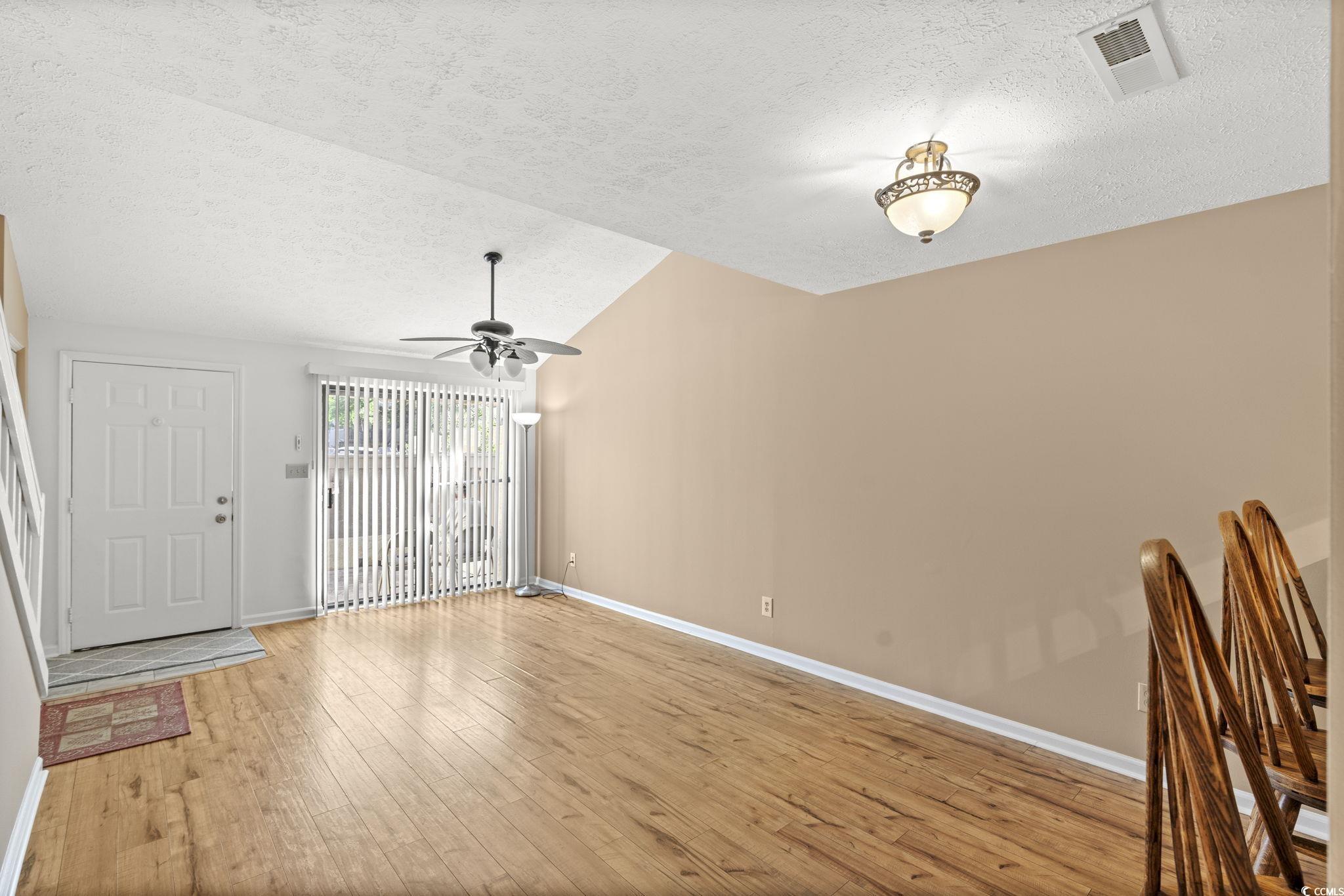 613 14th Avenue South, Unit 34 Surfside Beach, SC 29575 - Photo 8 of 37 Unfurnished living room featuring a textured ceiling, lofted ceiling, light wood-style floors, and ceiling fan
