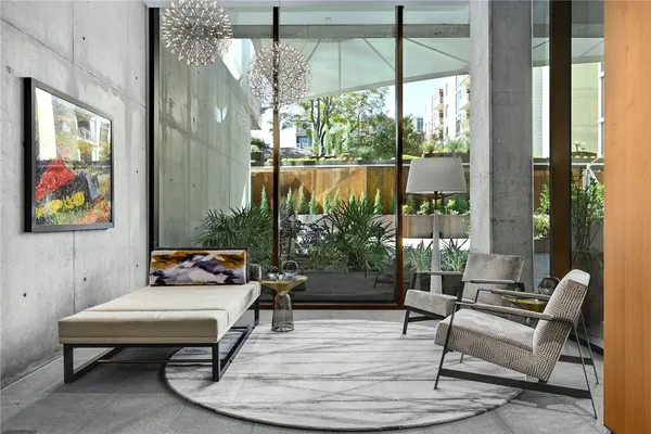 a living room with furniture kitchen view and a large window