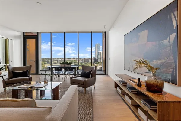 a living room with furniture and floor to ceiling windows