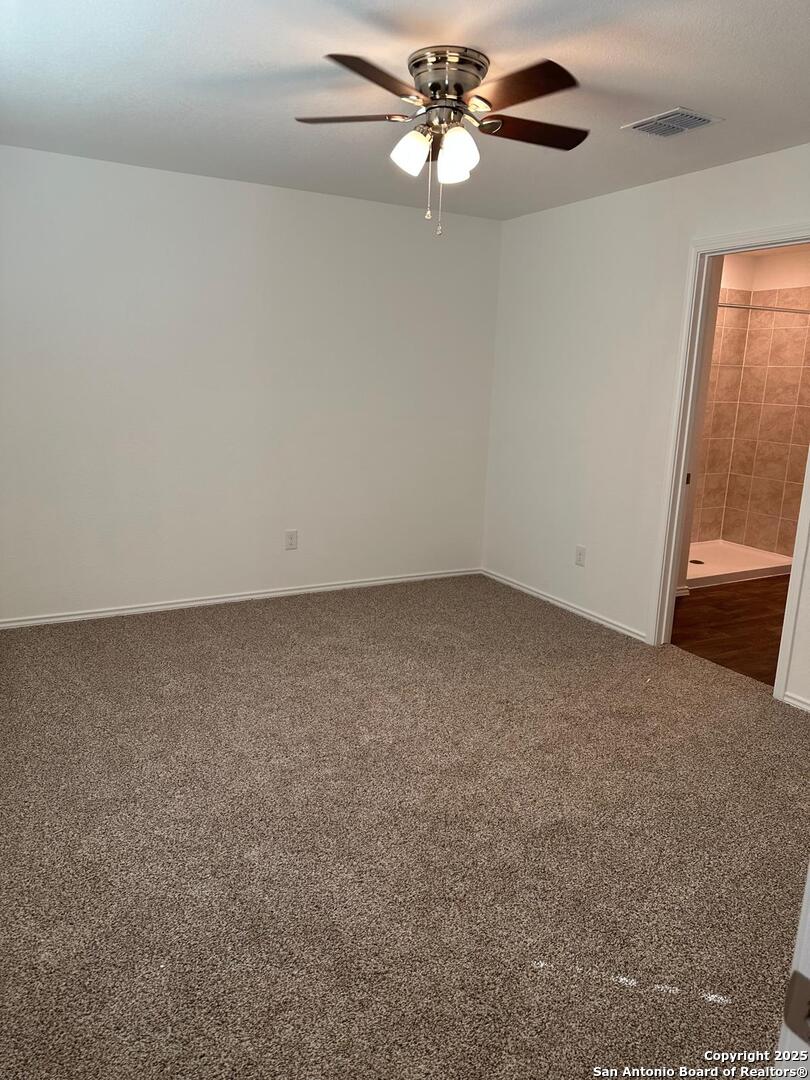 5032 Pitch Mark San Antonio, TX 78261 - Photo 14 of 21 an empty room with a chandelier fan and windows