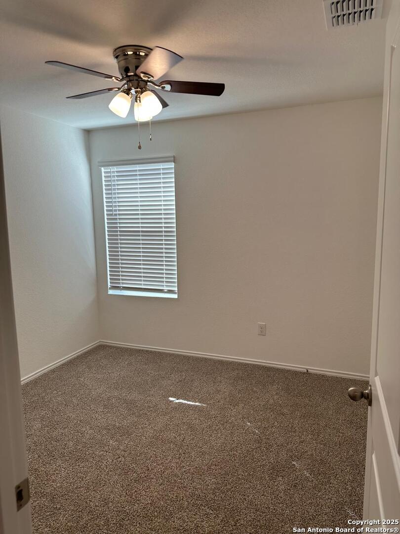 5032 Pitch Mark San Antonio, TX 78261 - Photo 16 of 21 an empty room with a chandelier fan and windows