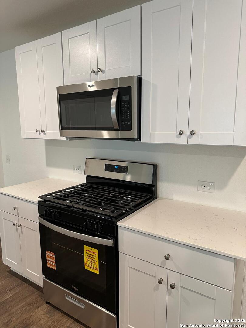 5032 Pitch Mark San Antonio, TX 78261 - Photo 3 of 21 a kitchen with stainless steel appliances granite countertop a stove a microwave and cabinets