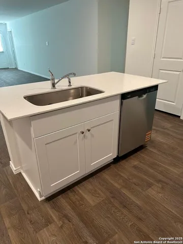 a kitchen with granite countertop a sink stove and refrigerator