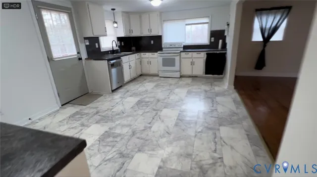 a kitchen with stainless steel appliances granite countertop a refrigerator a stove a sink and a microwave