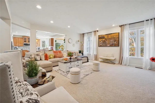 a kitchen with a stove a sink a refrigerator and a dining table with wooden floor