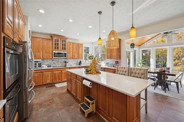 a kitchen with stainless steel appliances granite countertop a kitchen island hardwood floor sink stove and granite counter top