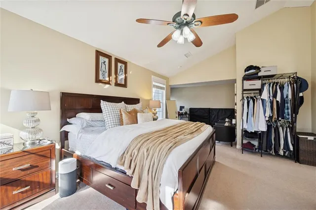 a spacious bedroom with a large bed and a chandelier