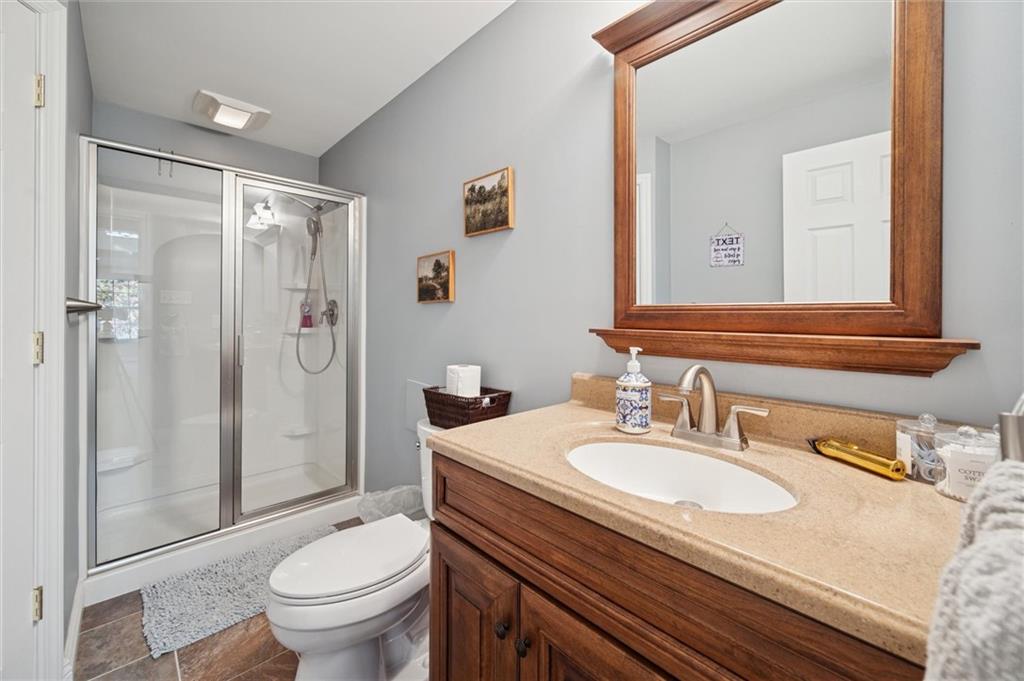 1005 Autumn Woods Drive Coraopolis, PA 15108 - Photo 30 of 50 a bathroom with a granite countertop sink toilet a mirror and shower